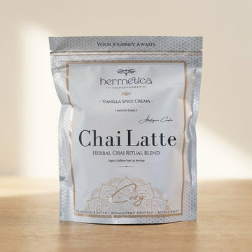 Cozy Adaptogenic Chai pouch on a wooden counter beside a steaming mug of chai
