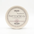 Overhead shot of a round Hermetica Hush low-dose melatonin sleep gummies container on a white background.