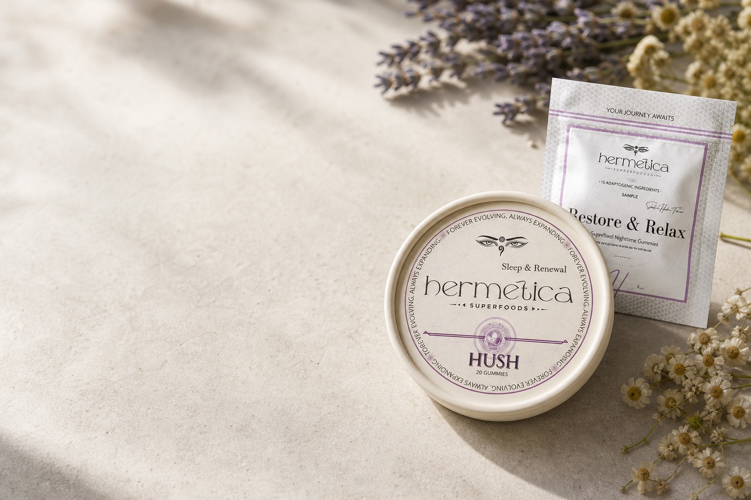 Hush Sleep Gummies tin beside its Restore and Relax sample packet on ivory linen