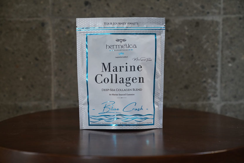 Blue Crush Marine Collagen pouch on a light oak table in morning light with eucalyptus and water
