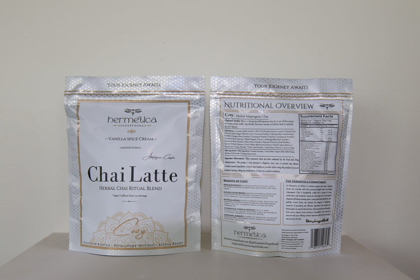 Cozy Adaptogenic Chai pouch on a wooden counter beside a steaming mug of chai