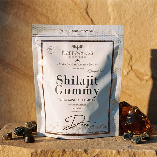 Deva Shilajit Gummies pouch on warm sandstone in golden light with mineral stones