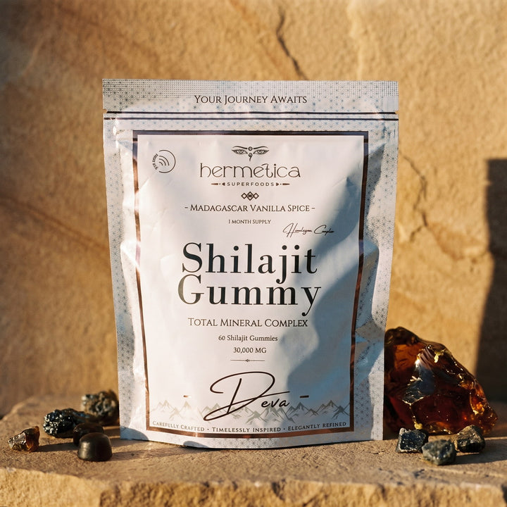 Deva Shilajit Gummies pouch on warm sandstone in golden light with mineral stones