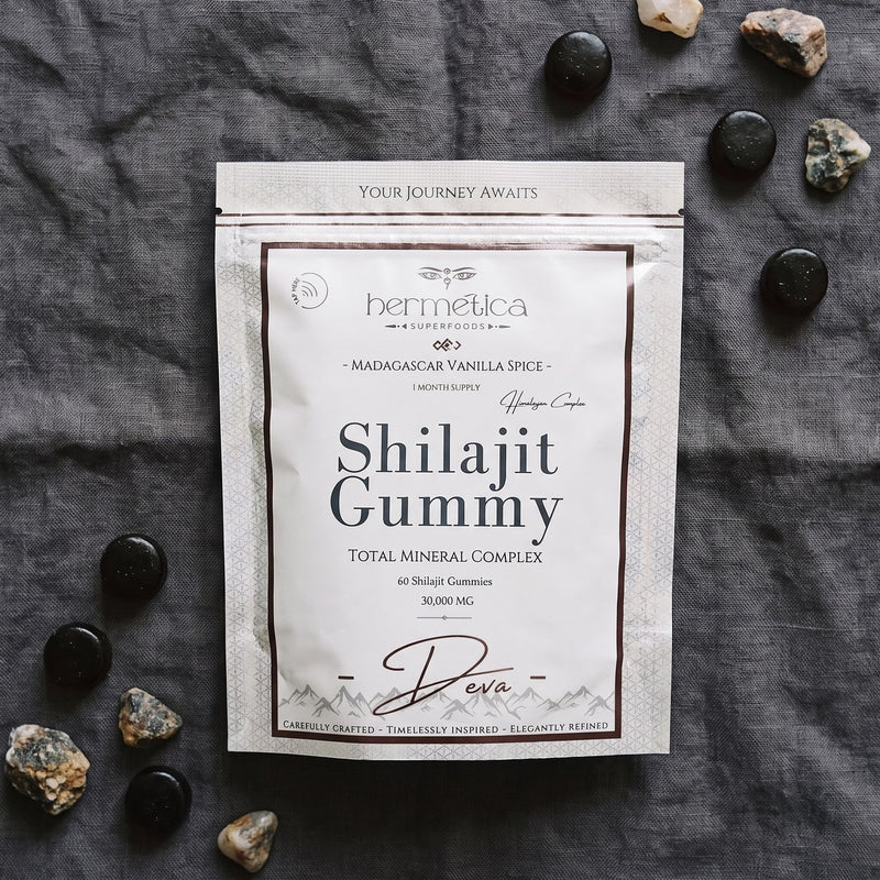 Overhead flat lay of the Deva Shilajit Gummies pouch on charcoal linen with gummies and minerals