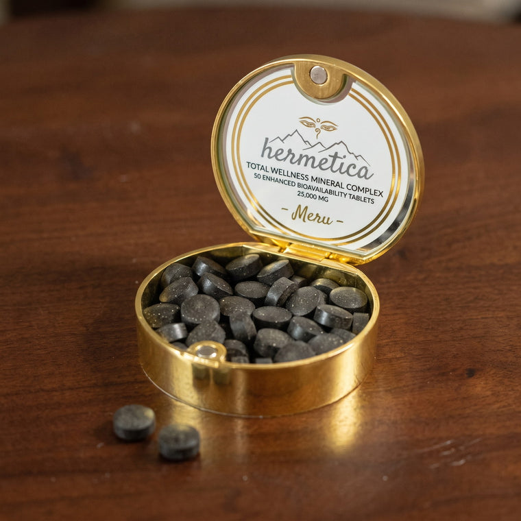 Open gold Meru tin with shilajit tablets on a walnut table in morning light