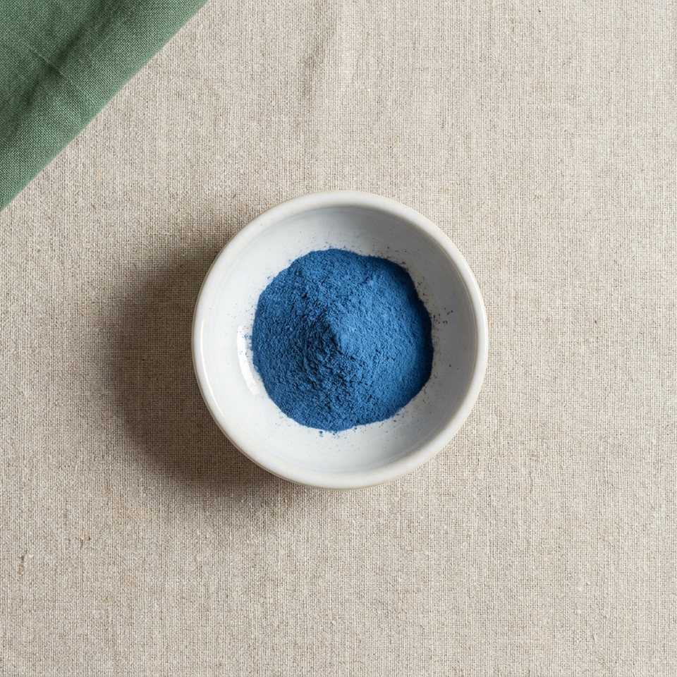 Blue spirulina extract powder in a small dish